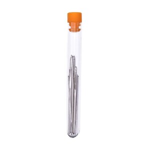 Op de afbeelding: Een doorzichtige glazen buis met een oranje deksel met daarin een bundel zilveren naalden.