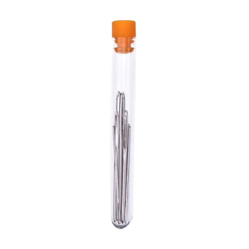 Op de afbeelding: Een doorzichtige glazen buis met een oranje deksel met daarin een bundel zilveren naalden.
