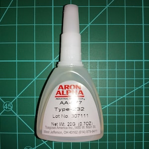 May include: A clear plastic bottle of Arron Alpha Industrial Glue, labeled AA-577 Type-232, Lot No. 307111, Net Wt. 20G (0.7OZ), Toagosei America Inc., 1450 W. Main St. West Jefferson, OH 43162 (614) 879-9411.