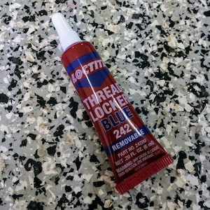 May include: A tube of Loctite Threadlocker Blue 242, a removable thread sealant. The tube is red with blue and white text, including the product name and warnings. It contains .20 fl oz (6 ml).