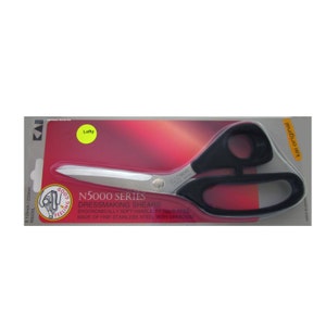 May include: Black dressmaking shears with a black handle and silver blades. The shears are packaged in a red and white plastic package with the text "N5000 Series Dressmaking Shears" and "Kai Original".