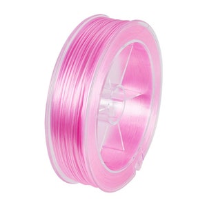 Peut inclure: Une bobine de cordon élastique rose, enroulée autour d'une bobine en plastique transparente. Le cordon est fin et translucide, avec un léger brillant.