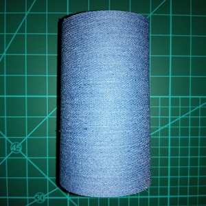 May include: A close-up of a blue denim fabric tube, possibly for crafting or sewing projects.
