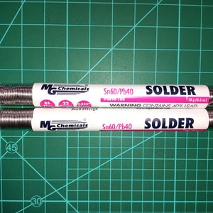 Puede incluir: Dos rollos de alambre de soldadura de plata, cada uno etiquetado como "MChemicals Sn60/Pb40 SOLDER" con una advertencia de que contiene 40% de plomo. Los rollos son de 18 gramos (0,6 onzas) cada uno.