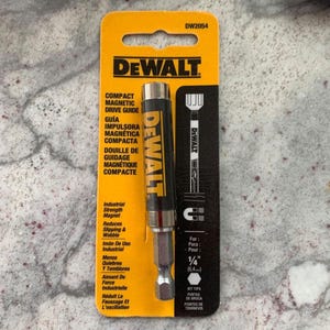 May include: A yellow and black DeWalt compact magnetic drive guide for 1/4 inch bits. The guide is designed to reduce slipping and wobbling when using drill bits.