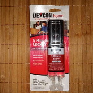 Pode incluir: Um pacote de Devcon Home 5 Minute Epoxy, um adesivo epóxi transparente de duas partes com uma resistência de 1500 psi. O pacote inclui uma seringa lacrável, uma bandeja de mistura e um palito. Adere a metal, madeira, vidro, cerâmica, concreto, pedra, porcelana e fibra de vidro.