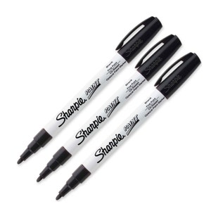 Könnte beinhalten: Drei schwarze Sharpie-Farbstifte mit weißen Etiketten. Die Etiketten lauten "Sharpie Paint" und "Black Fine Point Oil-Based Opaque Paint Marker".