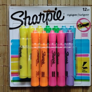 May include: A pack of 12 Sharpie highlighters with a smear guard feature. The highlighters are in various colours, including yellow, orange, green, blue, and purple. The packaging features the Sharpie logo and the text "12 ct Highlighter/Surligneur" and "Smear Guard".