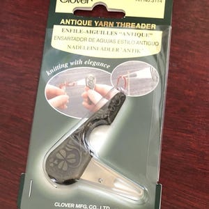May include: Antique yarn threader with a clover design on the handle. The packaging says "Antique Yarn Threader" and "Knitting with Elegance".