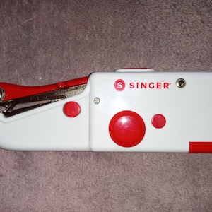 Máquina de coser portátil inalámbrica de mano; Máquina de coser de mano Singer roja y blanca