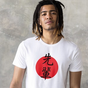 May include: White t-shirt with a red circle and black Japanese characters that read "先導" (pronounced "sendou") which means "leadership".
