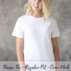 May include: A white unisex crew neck t-shirt with a regular fit. The t-shirt is shown on a model wearing blue jeans.