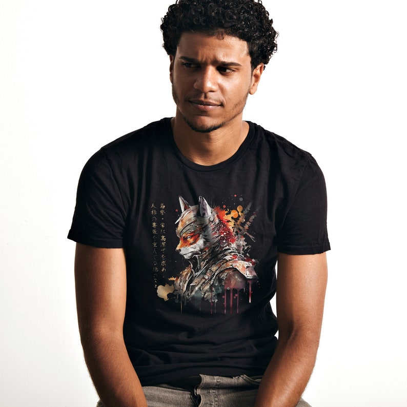 Puede incluir: Una camiseta negra con una ilustraci&oacute;n de acuarela de un zorro con un casco de samur&aacute;i. La ilustraci&oacute;n est&aacute; en tonos de naranja, rojo y amarillo. El texto en la camiseta est&aacute; en japon&eacute;s.