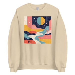 May include: A beige sweatshirt with a colorful abstract design featuring a river, hills, and a half moon. The design is in shades of blue, pink, yellow, and green.