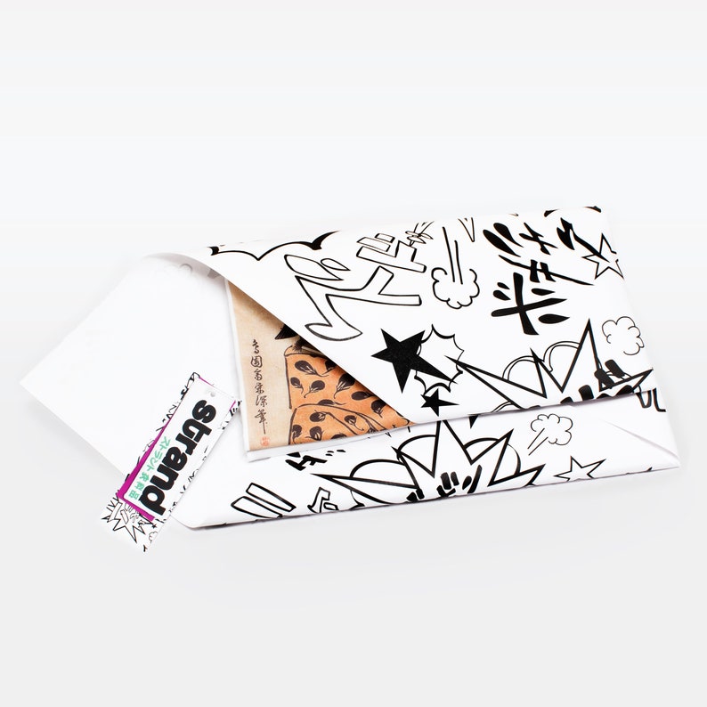 K&ouml;nnte beinhalten: Ein wei&szlig;er Umschlag mit einem schwarz-wei&szlig;en Comic-Design. Der Umschlag ist gefaltet und ein kleines St&uuml;ck Papier ragt oben heraus. Das Papier hat japanischen Text.