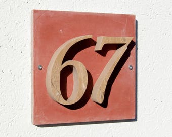 House number "67" of stone