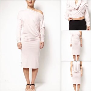 Peut inclure: Une robe rose pâle à une épaule avec des manches longues. La robe est ajustée et a un col en cowl. La robe est présentée sur un mannequin.