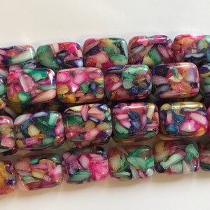 May include: A strand of rectangular, iridescent, multi-colored beads. The beads are made of a translucent material with embedded pieces of iridescent shell. The colors include pink, green, blue, and gold.