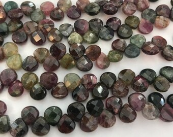 May include: A strand of faceted, green, pink, and black tourmaline beads. The beads are in the shape of a teardrop and have a shiny, polished finish.