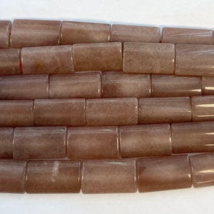 May include: A strand of light brown, rectangular gemstone beads. The beads are smooth and polished, with a subtle shimmer.