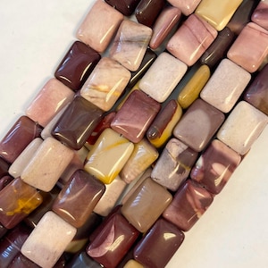 May include: A strand of colorful, rectangular, polished gemstone beads. The beads are a mix of red, brown, yellow, and white.