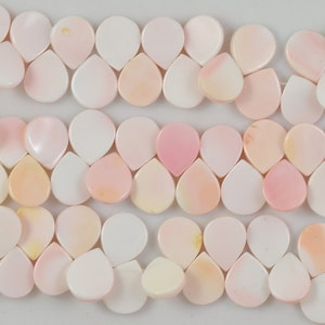 May include: A strand of pink and white shell beads in a teardrop shape.