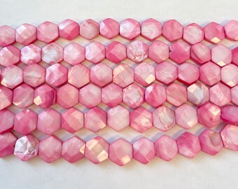 May include: A strand of pink iridescent shell beads with a faceted hexagonal shape.