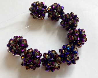 May include: A strand of iridescent purple and brown beaded jewelry with a cluster of beads forming a flower shape.