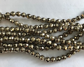May include: A strand of silver-toned faceted beads. The beads are round and have a metallic finish.