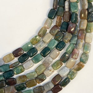 Può includere: Una collana di perline rettangolari in pietra preziosa di colore verde, marrone e bianco. Le perline sono lucidate e hanno una finitura liscia e naturale.