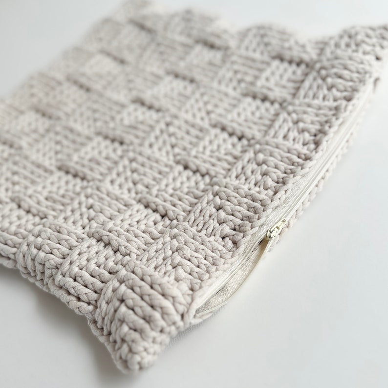 May include: A beige knitted zippered pouch with a woven texture. The pouch is open and the zipper is visible.