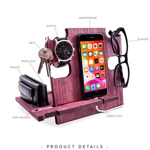 May include: A wooden desk organizer in a reddish-brown hue, featuring slots for a smartphone, glasses, watch, keys, and wallet. It includes a pen holder and a cable slot. The image also displays the words "PRODUCT DETAILS".