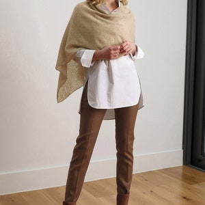 May include: A woman wearing a beige knitted shawl, a white button-down shirt, brown pants, and brown suede boots. The image is labeled "03-231".