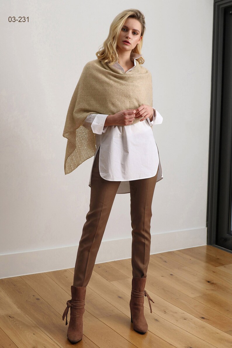 May include: A woman wearing a beige knitted shawl, a white button-down shirt, brown pants, and brown suede boots. The image is labeled "03-231".