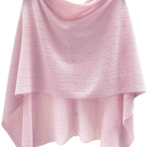 May include: A pink knitted poncho with a button closure. The poncho has a delicate openwork pattern.