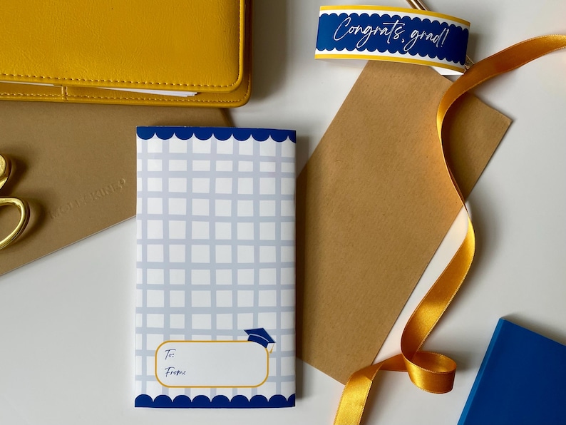 May include: A graduation gift set with a blue and white patterned card, a "Congrats, grad!" tag, a yellow ribbon, and a yellow wallet. The card has space for "To" and "From".