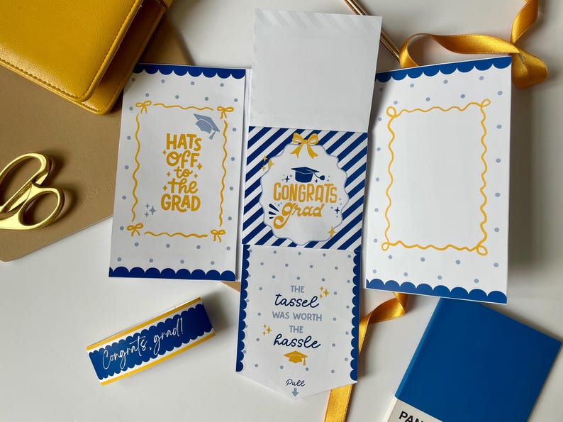 May include: A graduation-themed stationery set in blue and yellow. The set includes cards with phrases such as "Congrats Grad" and "Hats off to the Grad." A ribbon and a blue Pantone colour swatch are also visible.