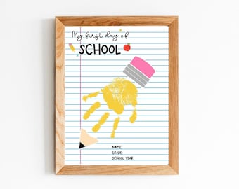 May include: Wooden framed print with a school theme. The print features a yellow handprint, a pencil, and the words "My first day of SCHOOL." Additional text includes lines for name, grade, and school year.