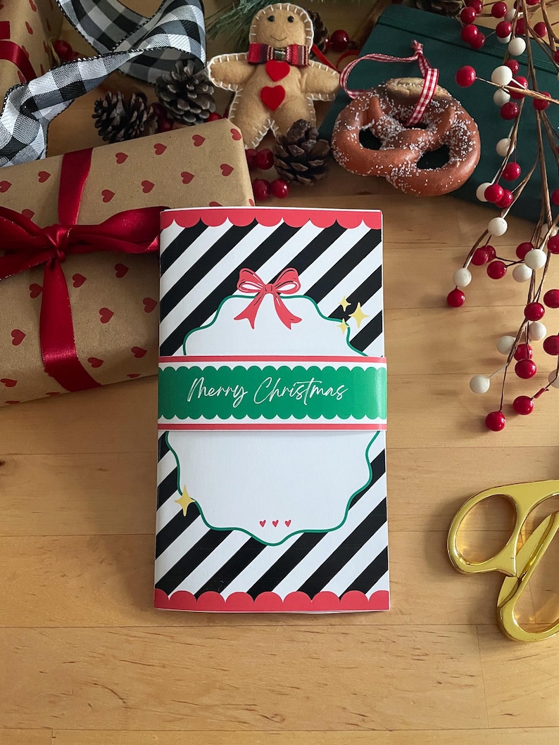 May include: A Christmas-themed notebook with a black and white striped pattern, red scalloped edges, and a green band that reads "Merry Christmas." The notebook has a red bow and star accents.