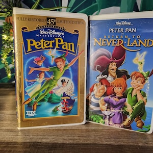 May include: Two VHS tapes of the Disney animated film "Peter Pan." The first tape is a 45th Anniversary Limited Edition, featuring Peter Pan, Wendy, and Captain Hook. The second tape is "Return to Never Land."
