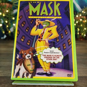 May include: DVD of "The Mask: Animated Series" with a green border. The cover features a cartoon character in a yellow suit and hat, with a green face and a dog wearing a mask. Text includes "The Mask" and "The Mask is always greener on the other side."