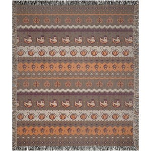 May include: A rectangular throw blanket with a repeating pattern of pumpkins, acorns, leaves, and birds in shades of brown, orange, and purple. The blanket has a fringed edge.