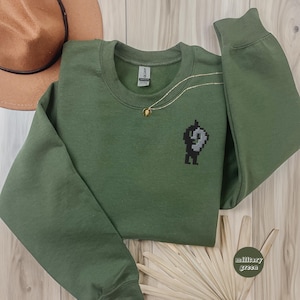 Sudadera de cuello redondo con bordado de Krobus / Jersey inspirado en Stardew Valley / Regalo para gamers / Merchandising de videojuegos acogedor / Camiseta de videojuegos / Pelican Town