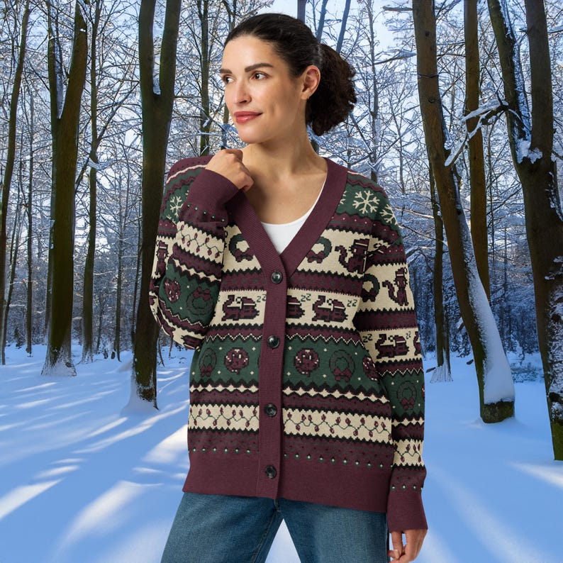 May include: Burgundy, green, and cream-colored cardigan sweater with a festive pattern. The button-down sweater features a V-neck and a repeating design of snowflakes, wreaths, and other holiday-themed elements. The sweater is worn over a white top.
