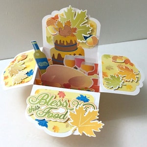 Carte pop-up Bless This Food pour Thanksgiving, vierge, dinde, vin, gâteau, automne, feuilles, gland, papier découpé, famille, amis, festin