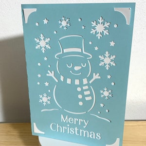 Joyeux Noël bonhomme de neige carte, étoiles, hiver, froid, bleu, blanc, carotte, écharpe, bâtons, extérieur, festif