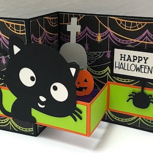 Carte pop-up d'Halloween , intérieur vierge , chat , papier découpé , pierre tombale , citrouille , maison recherchée , araignée , orange , noir , effrayant