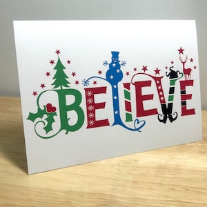 Carte de Noël Believe, vacances, bonhomme de neige, elfe, renne, magie, neige, étoiles, houx, joie