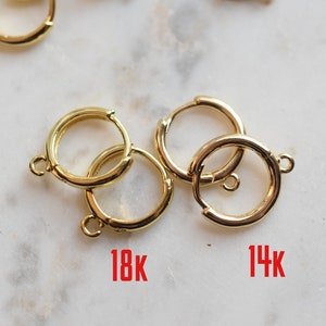 Puede incluir: Dos pares de pendientes de aro de oro, un par etiquetado como "18K" y el otro como "14K".