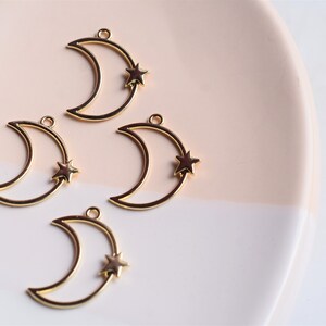 May include: Four gold-toned metal crescent moon charms with a small star charm attached to each moon.